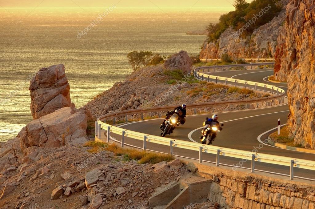 Moto parcheggiate davanti a un tramonto sul mare