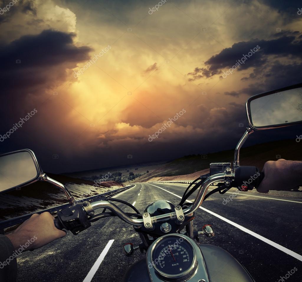 Moto che percorrono una strada verso un tramonto colorato